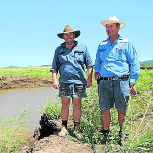 Rolleston broadacre farmer Max Mayne, Mayneland, pictured with son Dean in February at one of the major washouts in his farming country caused by the New Year floods.