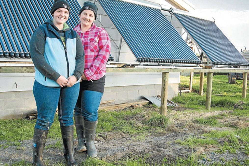 Sisters Donna Millwood and Kelly Lancaster with the new solar hot water system array installed at the Millwoods’ dairy.